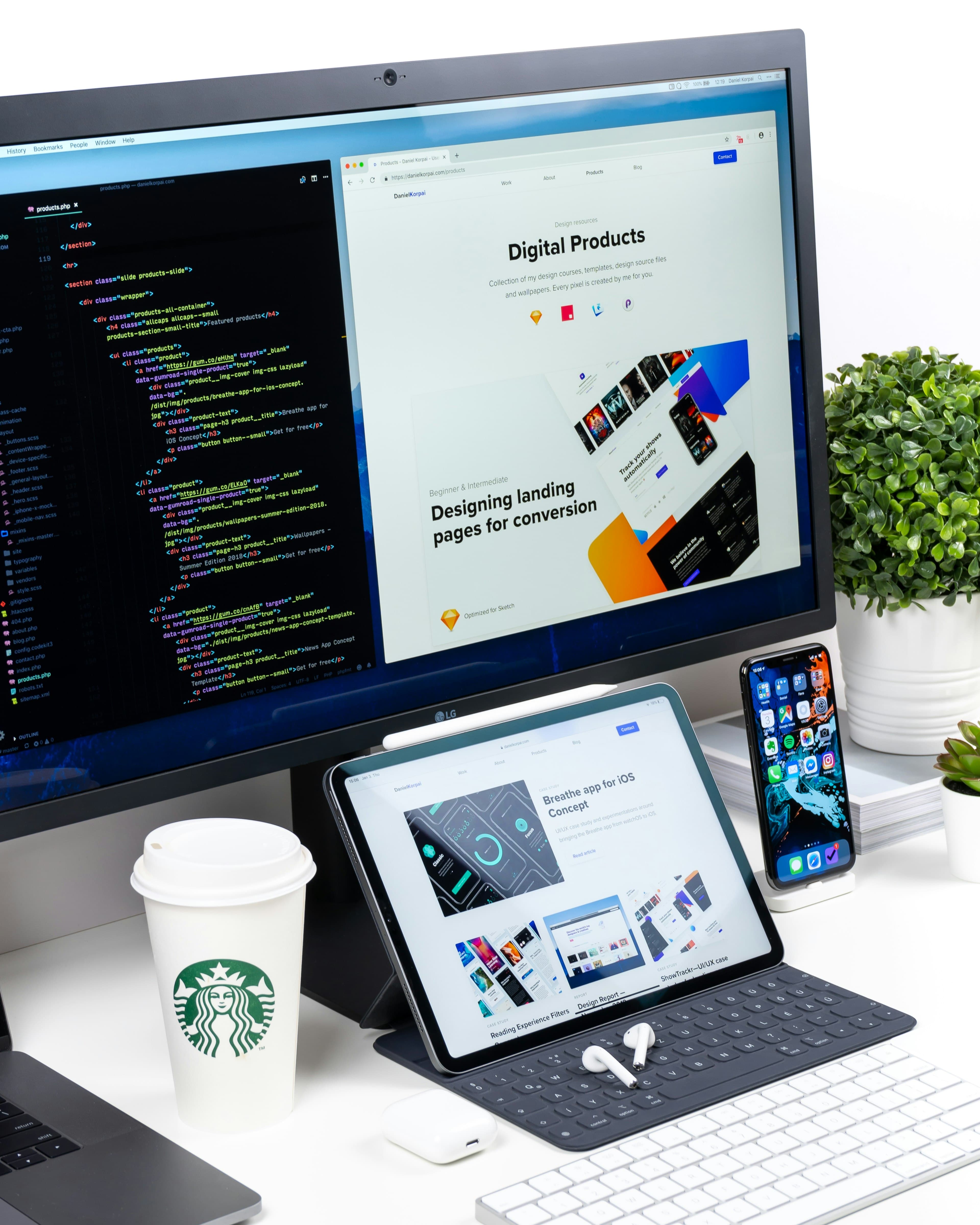 Designer workstation with a website design open across desktop, tablet and phone